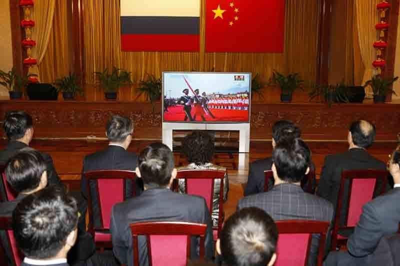Китайские эмигранты в России смотрят телевизионную трансляцию военного парада, посвященного 60-летию КНР