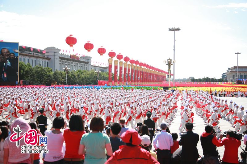Перед трибуной на площади Тяньаньмэнь проходит колонна танцующих людей с барабанами