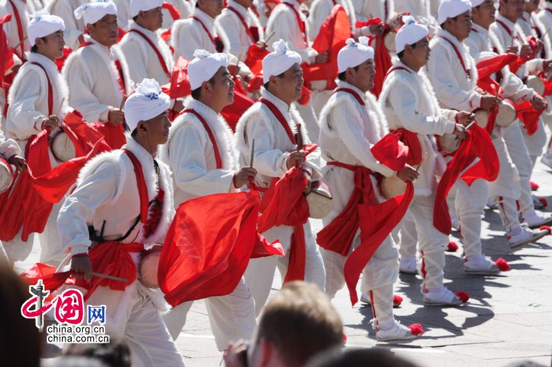 Перед трибуной на площади Тяньаньмэнь проходит колонна танцующих людей с барабанами