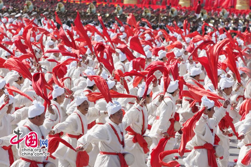 Перед трибуной на площади Тяньаньмэнь проходит колонна танцующих людей с барабанами