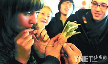 Иностранные послы надувают фигуры из сахара в одной из пекинских чайных 