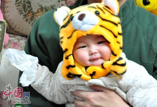 Милая китайская девочка в шапочке в виде головы тигра 2