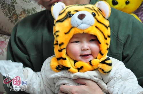 Милая китайская девочка в шапочке в виде головы тигра 5