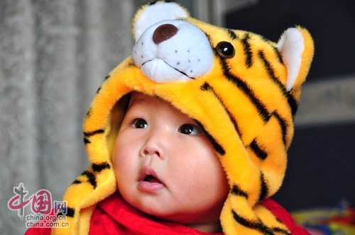 Милая китайская девочка в шапочке в виде головы тигра 6
