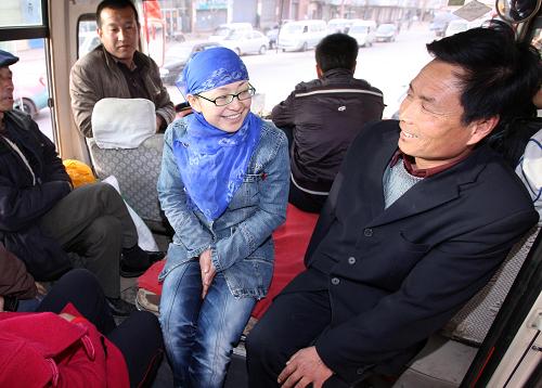 Депутат ВСНП Би Хунчжэнь (2-я справа) в городском транспорте города Пинлян провинции Ганьсу разговаривает с пассажиром (24 февраля). Би Хунчжэнь часто ездит в общественном транспорте, где она выслушивает мнения и предложения народа.