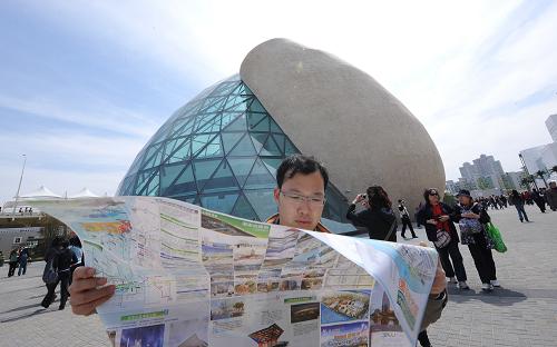 На фото: посетитель изучает карту парка павильонов ЭКСПО-2010 в Шанхае.