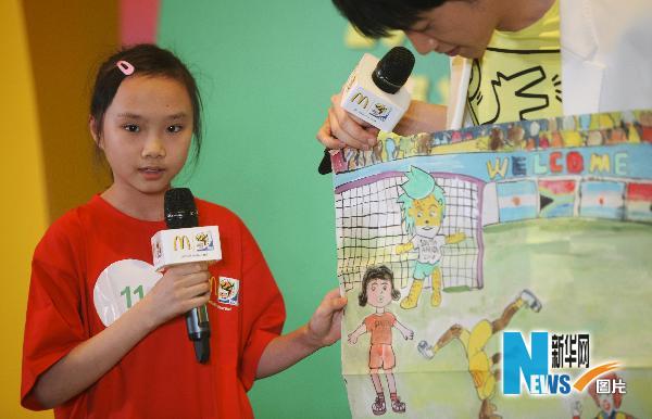 На фото: 12 мая, девочка в финале конкурса демонстрирует свою картину на тему футбола.