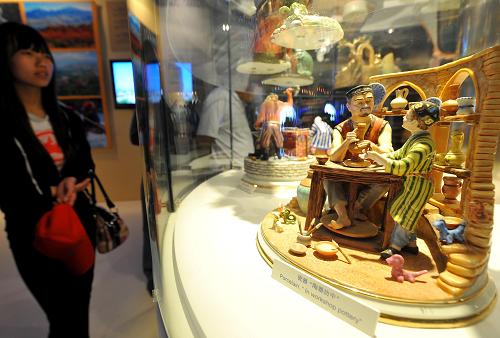 На фото: 10 мая, посетитель смотрит на изделия из керамики и фарфора в павильоне Узбекистана.