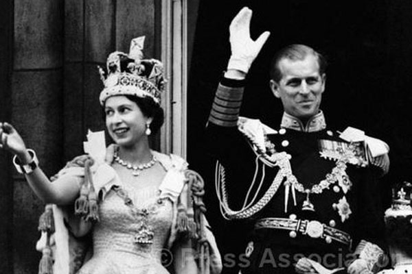 На фото: 2 июня 1953 года, королева Елизавета II и Герцог Эдинбургский Филипп Маунтбеттен на церемонии коронации машут руками.