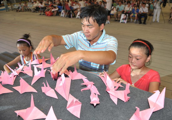 Тысячи посетителей в Парке павильонов ЭКСПО с бумажными журавлями выражают соболезнования пострадавшему уезду Чжоуцюй