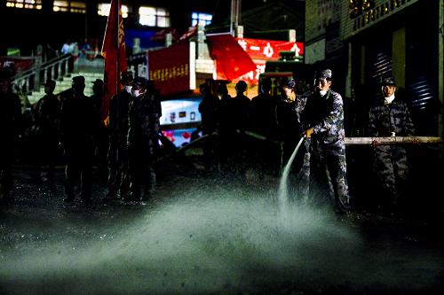 На фото: вечером 17 августа, офицеры и солдаты из Ланьчжоуского военного округа очищают улицу в уезде Чжоуцюй.