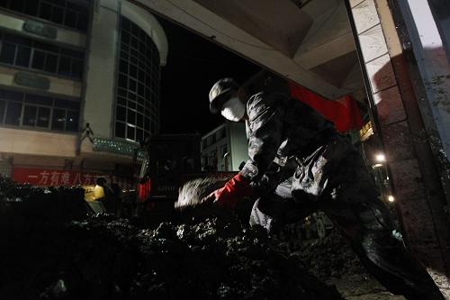 На фото: вечером 17 августа, офицеры и солдаты из Ланьчжоуского военного округа очищают от ила супермакет в уезде Чжоуцюй провинции Ганьсу.