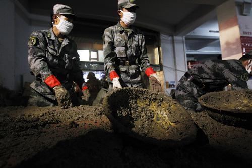 На фото: вечером 17 августа, офицеры и солдаты из Ланьчжоуского военного округа очищают от ила супермакет в уезде Чжоуцюй провинции Ганьсу.