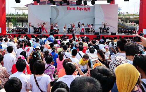 На фото: 26 августа, посетители смотрят выступление артистов с барабанами из Южной Кореи на Площади Азии в Парке павильонов ЭКСПО.