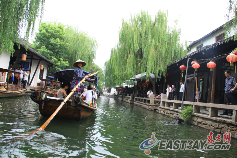 На фото: представители разных стран совершили путешествие по древнему поселку Чжоучжуан в лодках с черными навесами (упэнчуань).