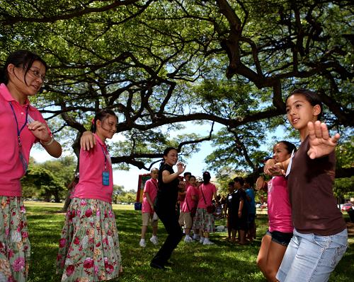 На фото: 28 августа, в Гонолулу США гавайская девочка (первая справа) учит китайских детей и учителей местному танцу «Хула».
