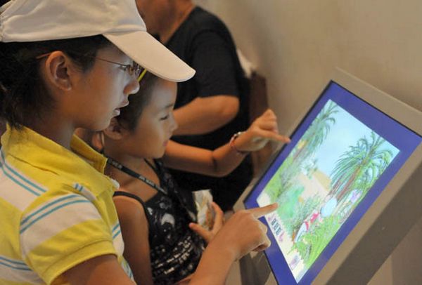 На фото: посетители читают информацию о Тунисе в Павильоне Туниса на ЭКСПО-2010 в Шанхае.