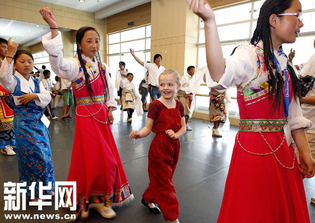 8-летняя американская девочка Ли Сяофэн (вторая справа) танцует вместе и тибетскими школьникамииз провинции Цинхай.