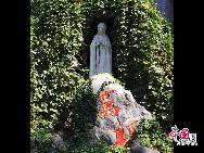 Белая статуя Девы Марии среди искусственных гор