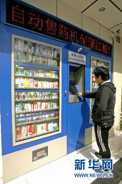 На фото: 8 марта 2011 года, местный житель на проспекте Цзефан в районе Ханькоу города Ухань провинции Хубэй покупает лекарства в уличном автомате. 