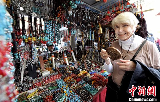 На фото: на знаменитой улице Баркхор в Лхасе интуристка выбирает сувенир.