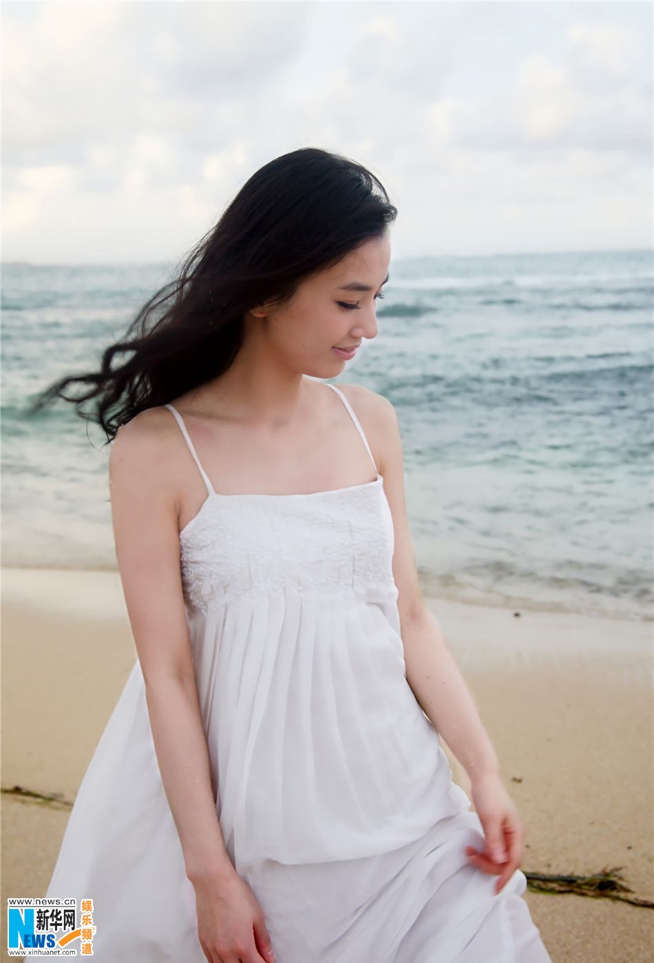 Хуан Шэнъи в белом платье у моря