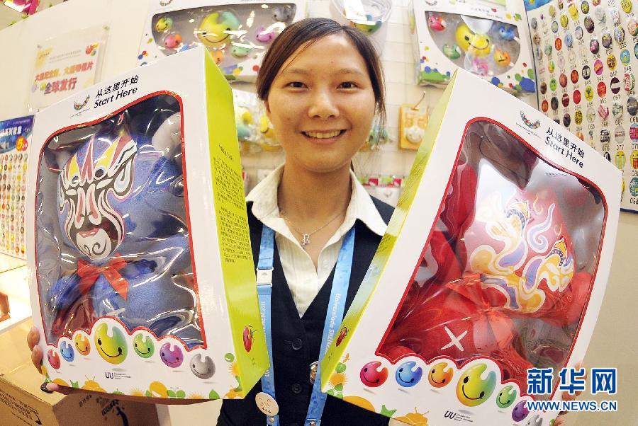 На фото: сотрудница демонстрирует игрушки с масками пекинской оперы.