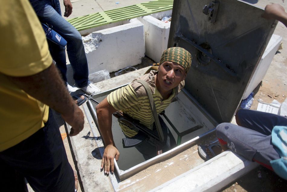 На фото: солдат оппозиции выходит из тайного бункера Каддафи.
