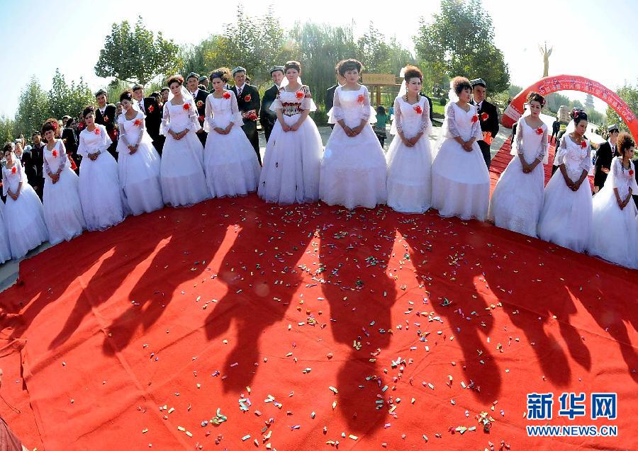 На фото: 19 октября новобрачные участвуют в коллективной свадьбе с национальным колоритом в СУАР. 
