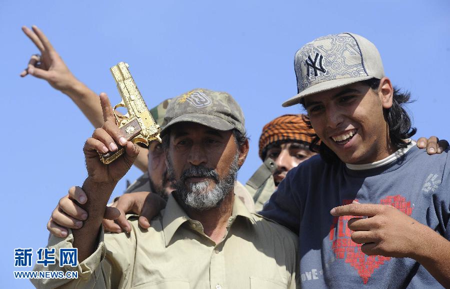 20 октября солдаты в Сирте хвастались золотым пистолетом, который был изъят во время ареста Муамара Каддафи.