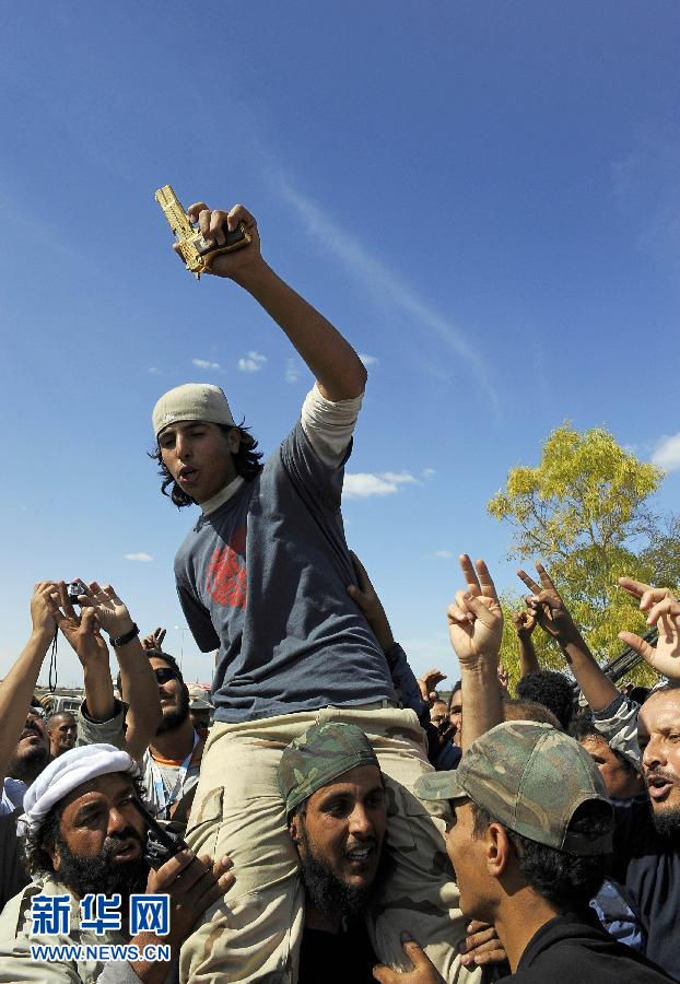 20 октября солдаты в Сирте хвастались золотым пистолетом, который был изъят во время ареста Муамара Каддафи.