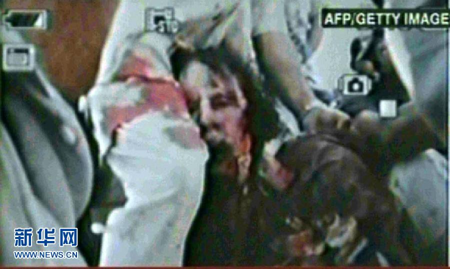На фото: телеканал «Аль-Джазира» показывает видео, снятое мобильником во время плена Муамара Каддафи