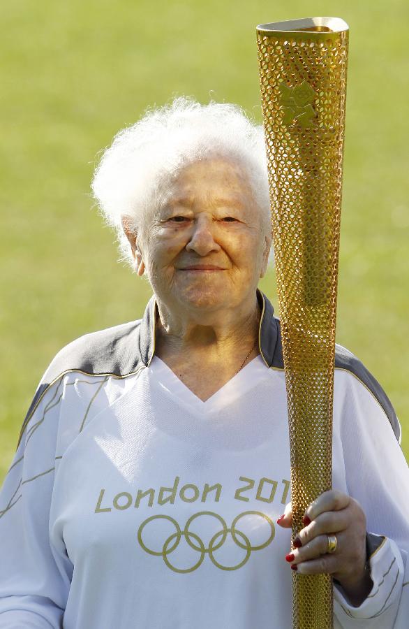 На фото: 19 марта в Лондоне, самая старая участница эстафеты факела Олимпиады -2012 Дина Гулд, которой в мае исполнится 100 лет, демонстрирует факел Олимпийских игр 2012 года.