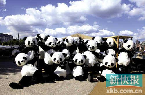 На фото: чэндуские люди-панды фотографируются у реки Темзы в поддержку китайских спортсменов.