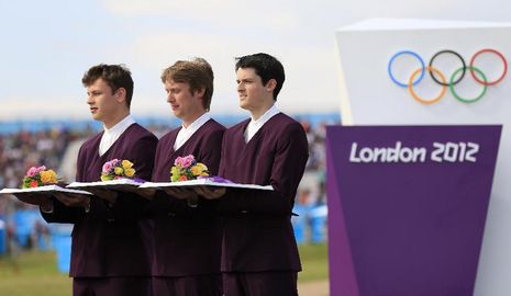 Фото: Волонтеры-мужчины на церемониях награждения Олимпиады-2012, подносящие цветы и медали
