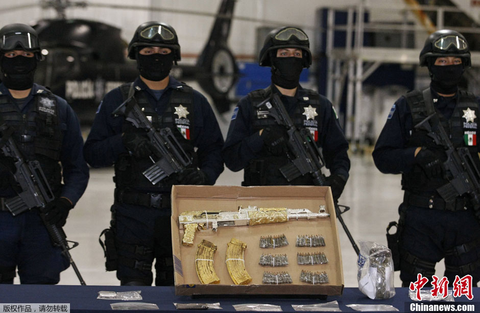 На фото: 12 сентября по местному времени в столице Мексики полиции показывают позолоченный АК-47 у арестованного наркоборона Ramiro Pozos.