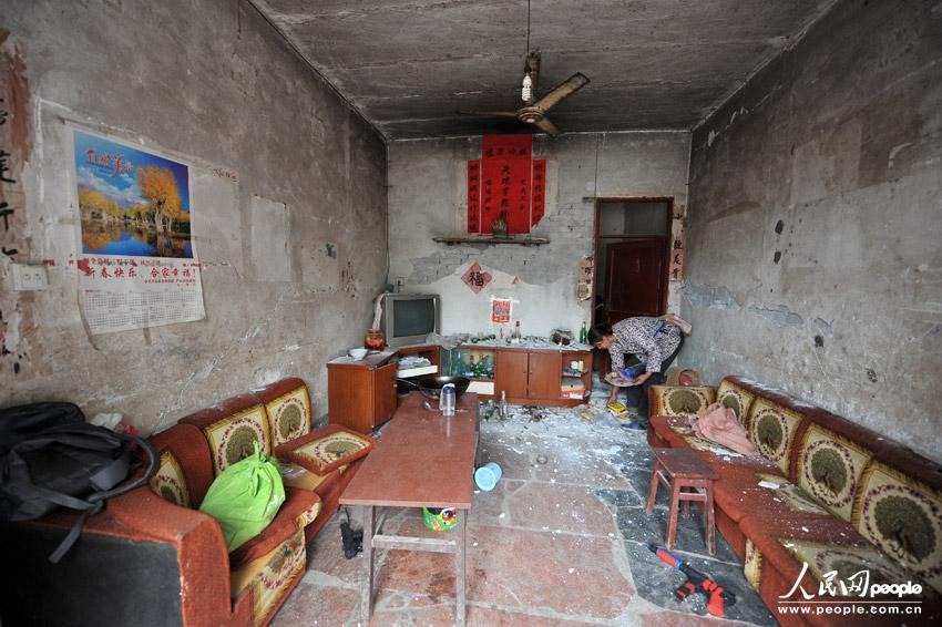 На фото: в деревне Гучэн уезда Лушань, Жэнь Тилянь убирает мусор дома после землетрясения. 