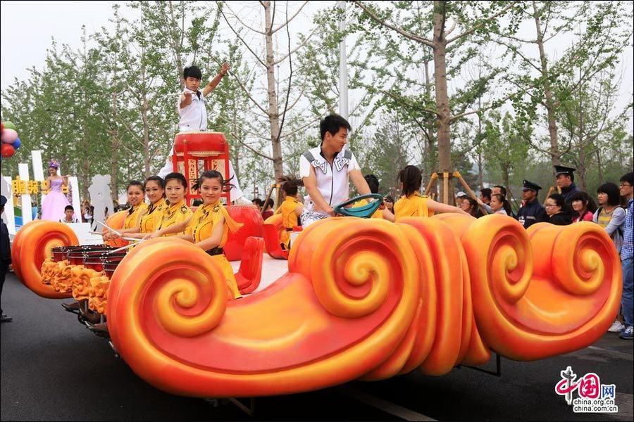 Пекинская ярмарка садово-паркового искусства: украшенные машины и девушки в нарядах, изображающих известные достопримечательности района Фэнтай