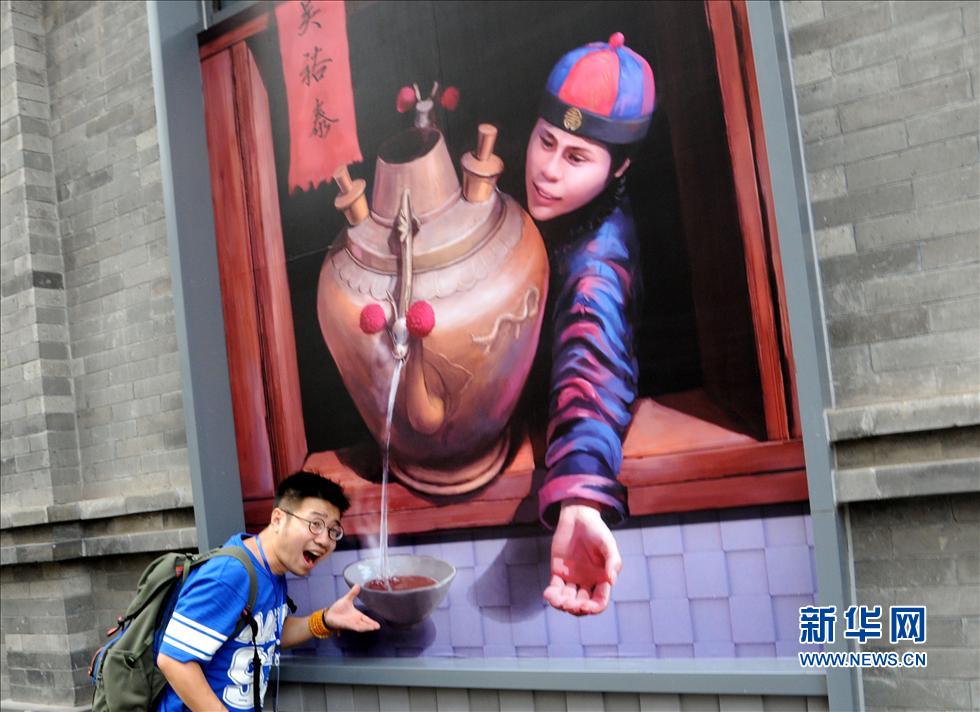 7 августа, турист фотографировался на фоне 3D картины, в тот день открылся 4-й фестиваль культуры 'Пекин Цяньмэнь'.