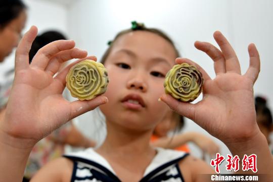 29 августа группа детей на улице Фэнмэньлу г.Сучжоу своими руками делают лунные пряники для встречи предстоящего праздника середины осени. 