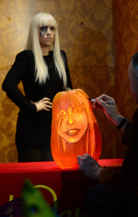 22 октября в Музее мадам Тюссо в Нью-Йорке мастер по резке из тыквы Хью МакМагон сравнивает свою работу с восковой фигурой Леди Гага.