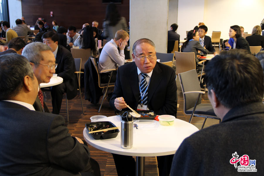 Се Чжэньхуа во время трапезы беседует с экспертами для изучения стратегии ведения переговоров.