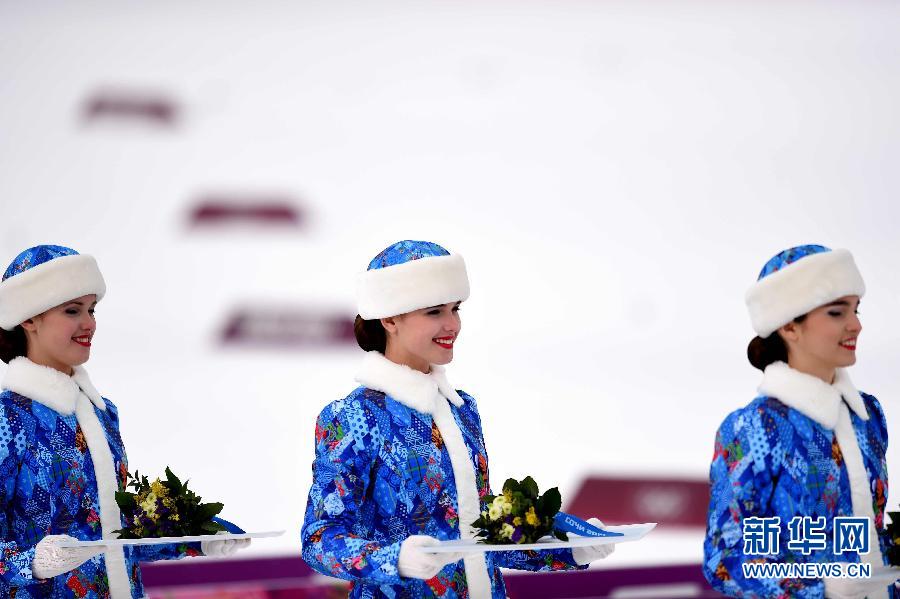На фото: 9 февраля, церемониальные девушки во время церемонии подачи цветов после соревнований по лыжным гонкам среди мужчин, (15 км классический стиль+15 км свободный стиль).