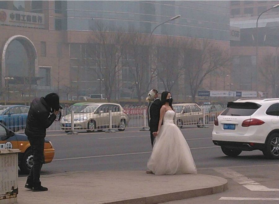 Влюбленные пары в Пекине снимаются для свадебной фотосессии в противогазах 