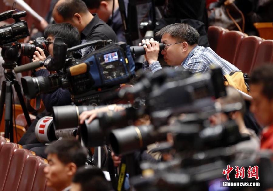 На фото: Журналист использует бинокль, чтобы наблюдать за заседанием.