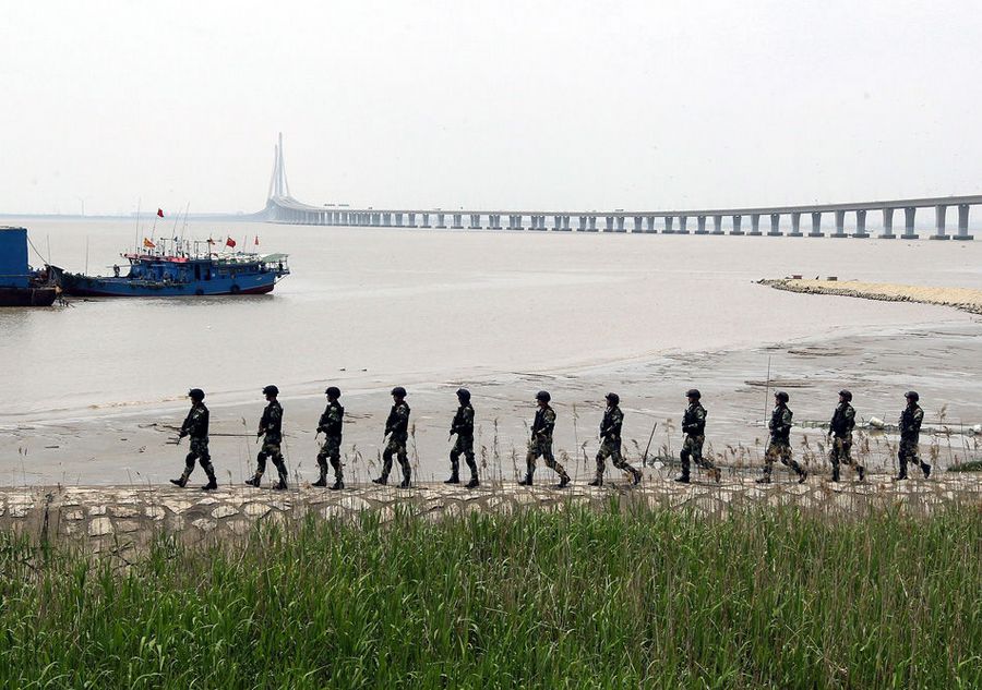 15 мая солдаты вооруженной полиции патрулируют территорию у побережья реки Янцзы в Шанхае. 