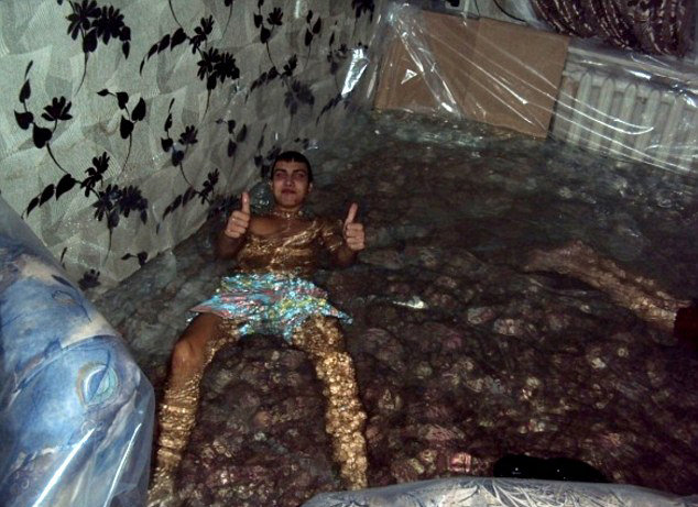 На фото: мальчики плавают и ныряют в самодельном бассейне из гостиной, мебель и батарея покрыты слоем пластиковой пленки.