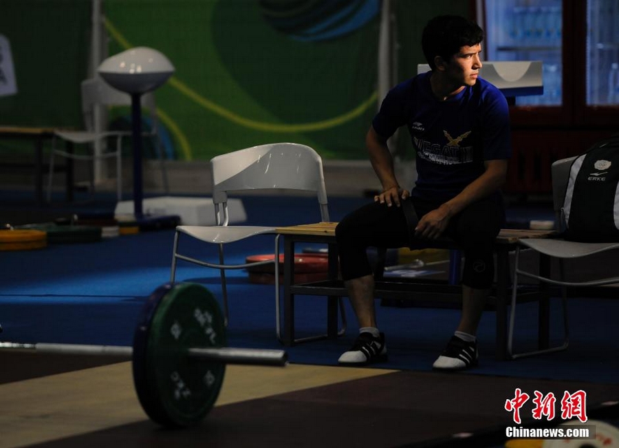 21 августа соревнование по мужской тяжелой атлетике состоялось в Нанкинском международном выставочном центре. На фото: молодой спортсмен, у которого в этот день не было соревнований, упорно готовился в тренировочной зоне.