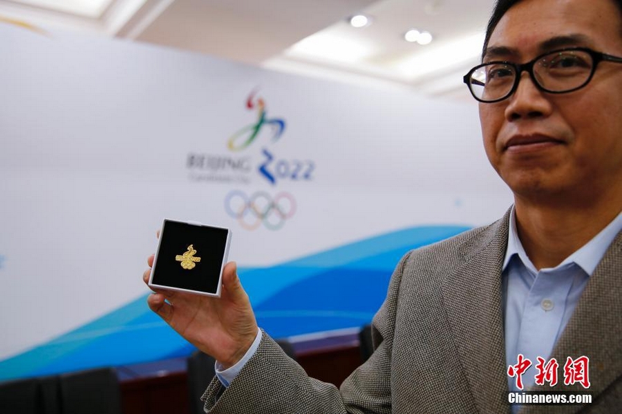 На фото: 4 ноября заместитель министра Отдела новостной пропаганды Гао Чао демонстрирует значок, разработанный для проекта выдвижения кандидатуры Пекина на проведение Зимней Олимпиады-2022. 