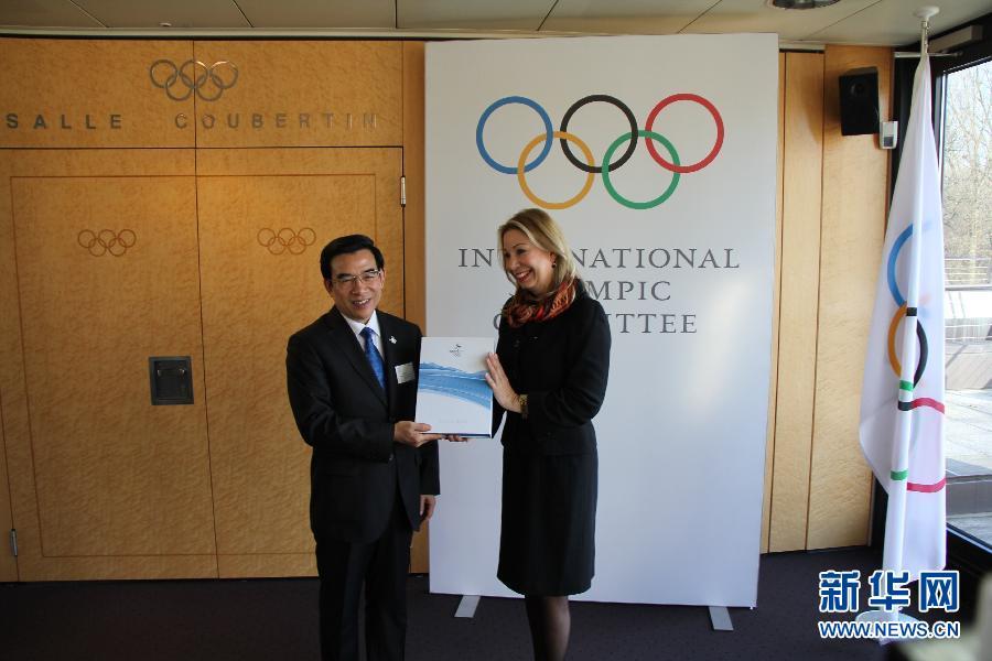 мэр Пекина Ван Аньшунь (слева) подает директору МОК по взаимоотношениям городов-кандидатов на проведение Олимпийских игр Жаклин Барретт «Доклад о заявке».